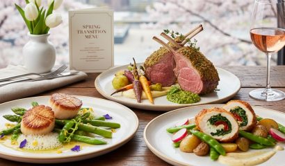 Spring transition restaurant menu with herb crusted rack of lamb, stuffed chicken breast, seared scallops, seasonal vegetables, and rosé wine by a window with blooming trees in Chicago